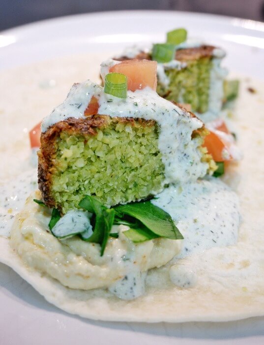 Falafel serviced with hummus, tzatziki sauce and greens.
