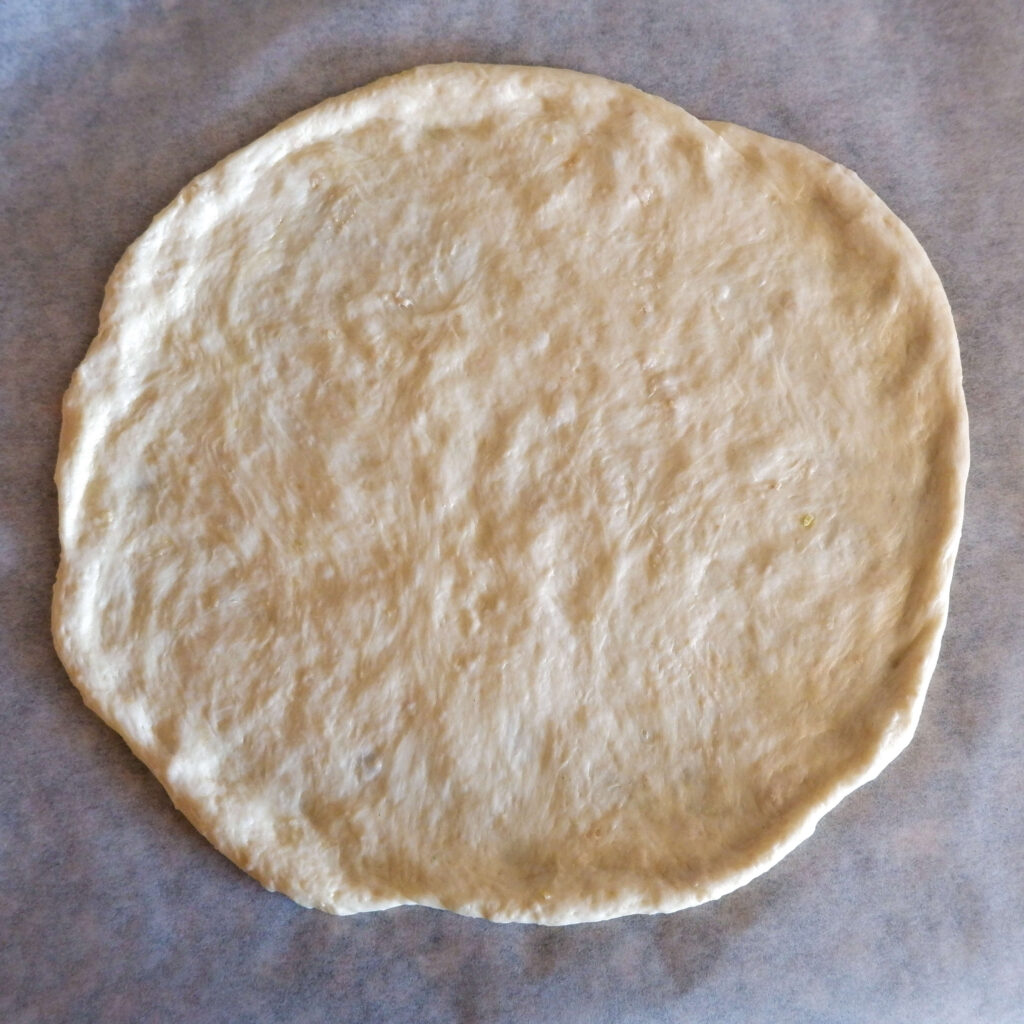 Smooth elastic Italian pizza dough on floured surface — homemade pizza dough recipe