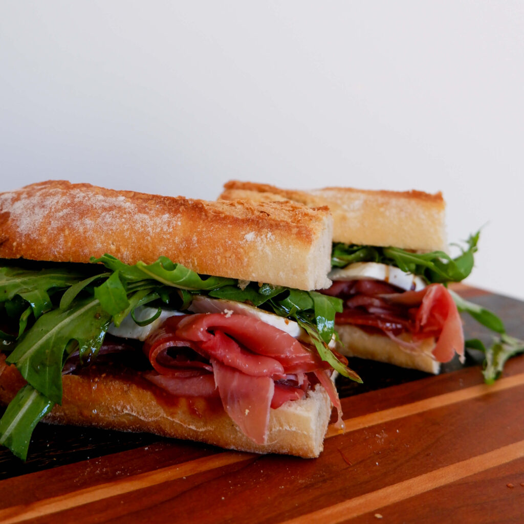 Presunto,fig, and brie sandwiches on cutting board