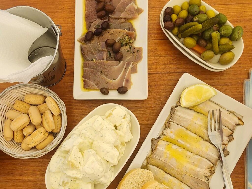 A typical spread of Spanish tapas from Southern Spain including sliced pork, tuna, pickles, and a Spanish potato salad