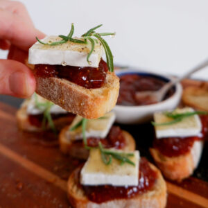 Fig and brie crostini on broiled baguette slices drizzled with balsamic and hot honey