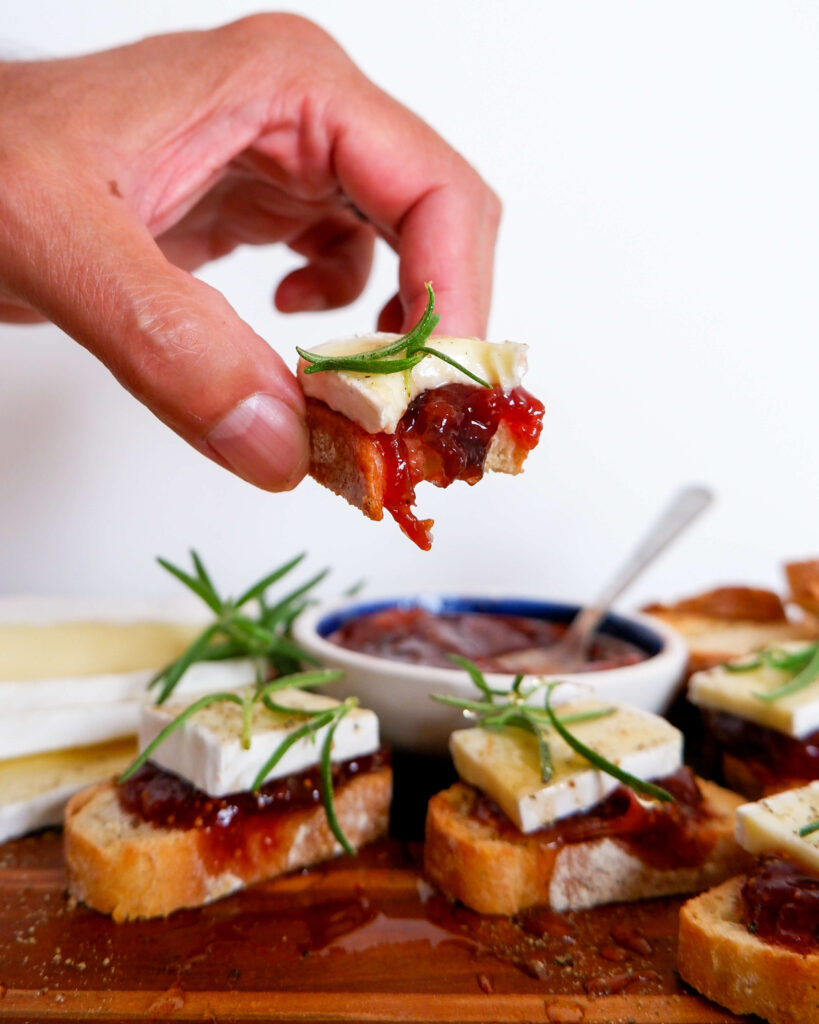 Close-up of fig jam and creamy brie melting slightly on golden toasted baguette